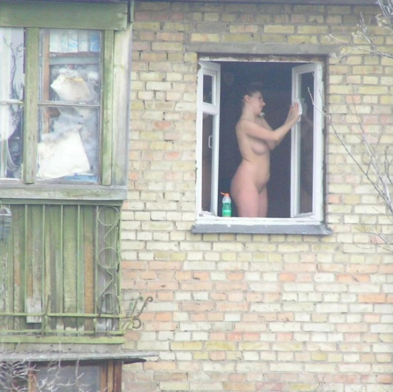 Обнаженная девушка высматривает принца в окно
